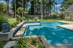 Geometric swimming pool with water features and tanning ledge