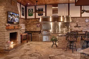 Sheltered outdoor kitchen with fireplace and kitchen island