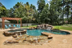 Luxury swimming pool with rock waterfall, tanning ledge and custom spa