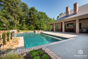 Inground geometric swimming pool with custom spa and water feature